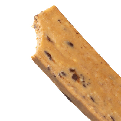 A close-up image of unwrapped and partially bitten Peanut Butter Chocolate Chip Cookie Dough bar.