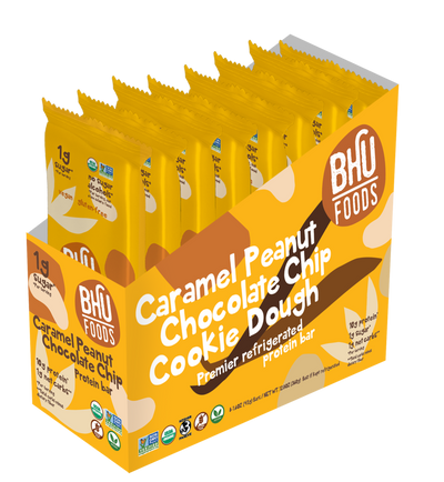 An open box of Caramel Peanut Chocolate Chip Cookie Dough Premier Refrigerated Protein Bar with eight individually wrapped bars (1.6oz each) inside.