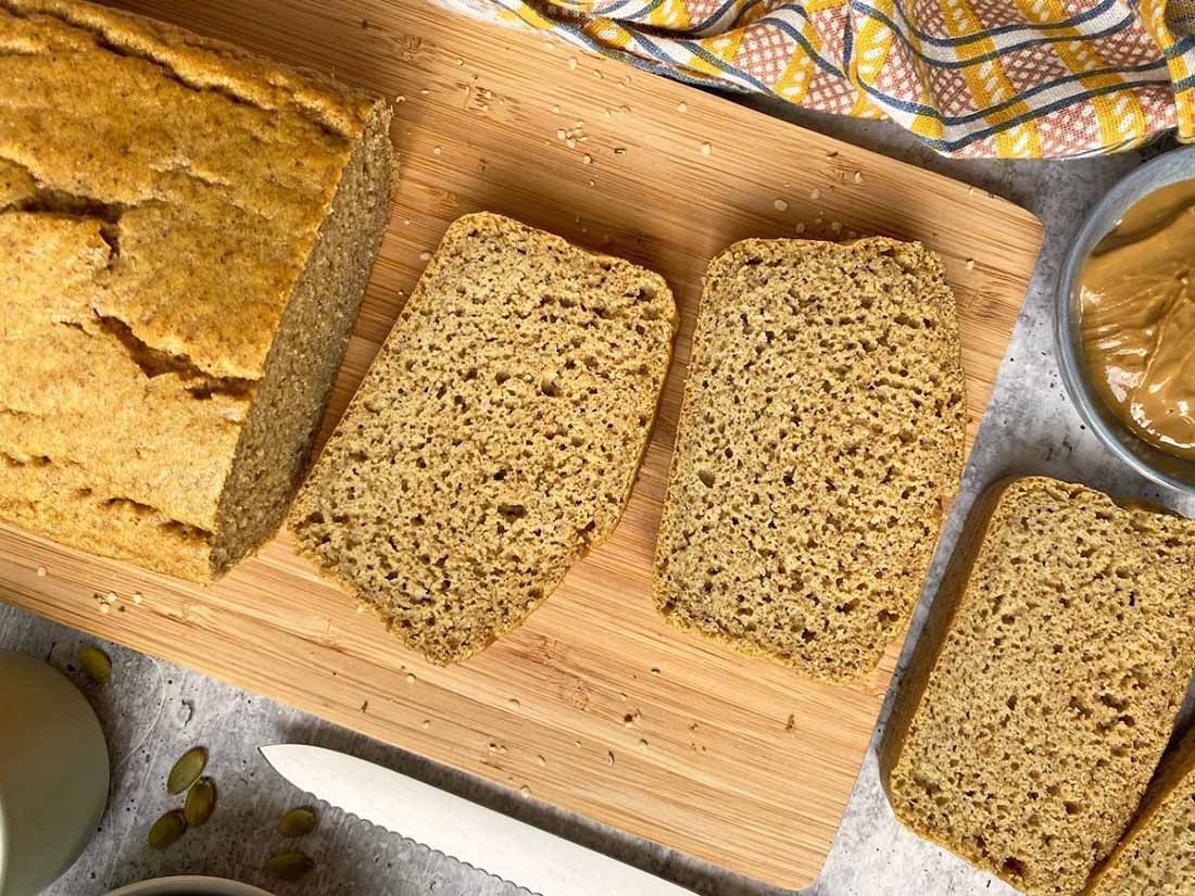 Slices of healthy tiger nut bread on a cutting board with Bhu Foods Tigernut Butter