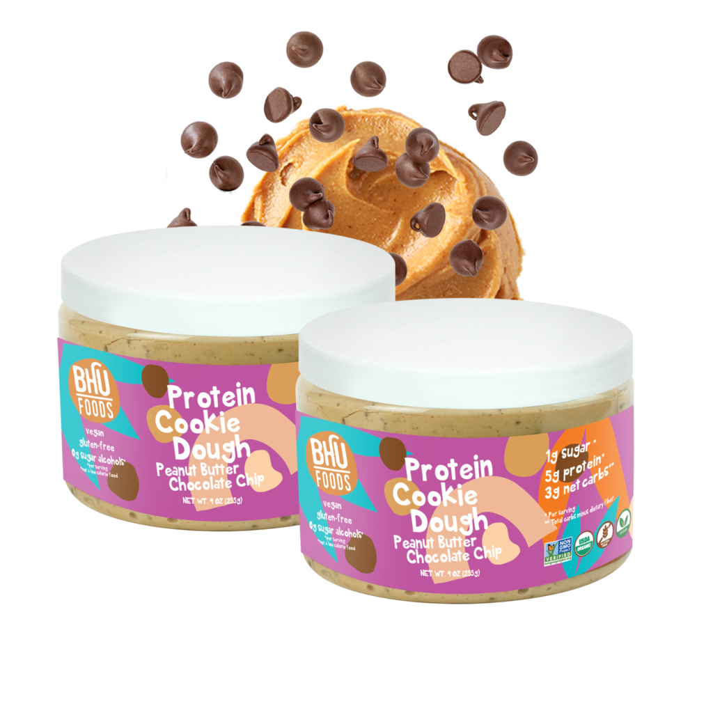 Two jars of Peanut Butter Chocolate Chip Protein Cookie Dough (9oz each) with some peanut butter and chocolate chips behind.