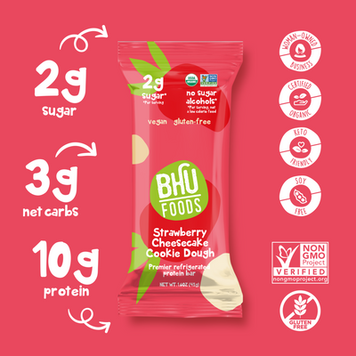 An individually wrapped Strawberry Cheesecake Cookie Dough Premier Refrigerated Protein Bar has 2g sugar, 3g net carbs and 10g protein. It is certified organic, keto friendly, soy free, non-GMO project verified, gluten free and a woman-owned business.